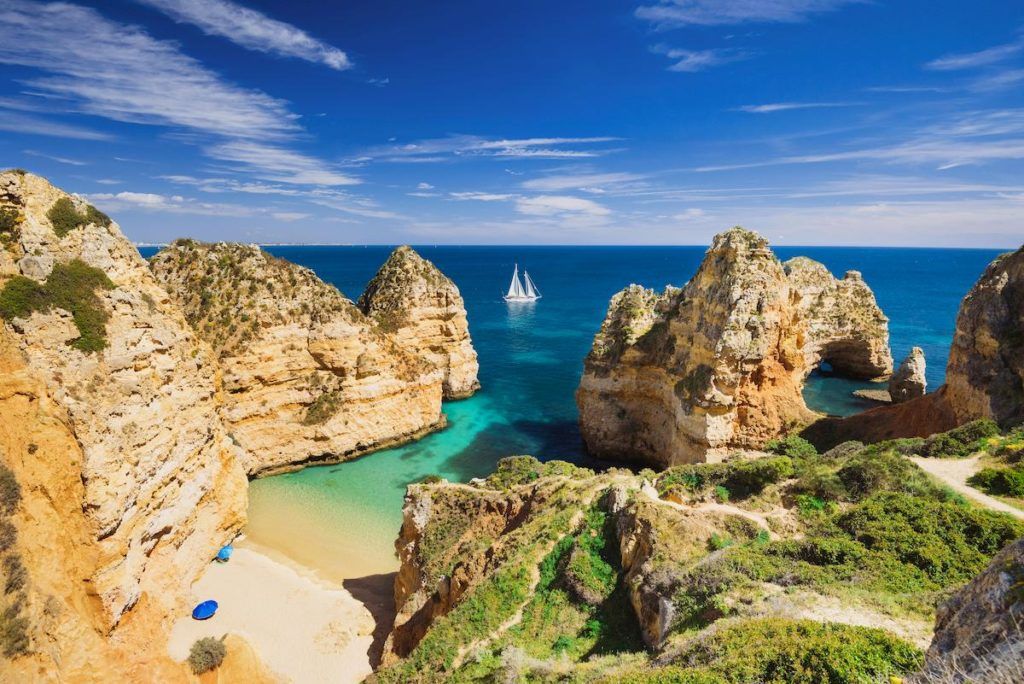 What to see in Portugal: brown rocks on sea under the sun of Algarve