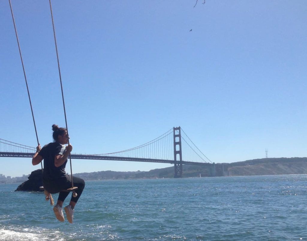Woman on a swing in Kirby Cove in front of the Ocean