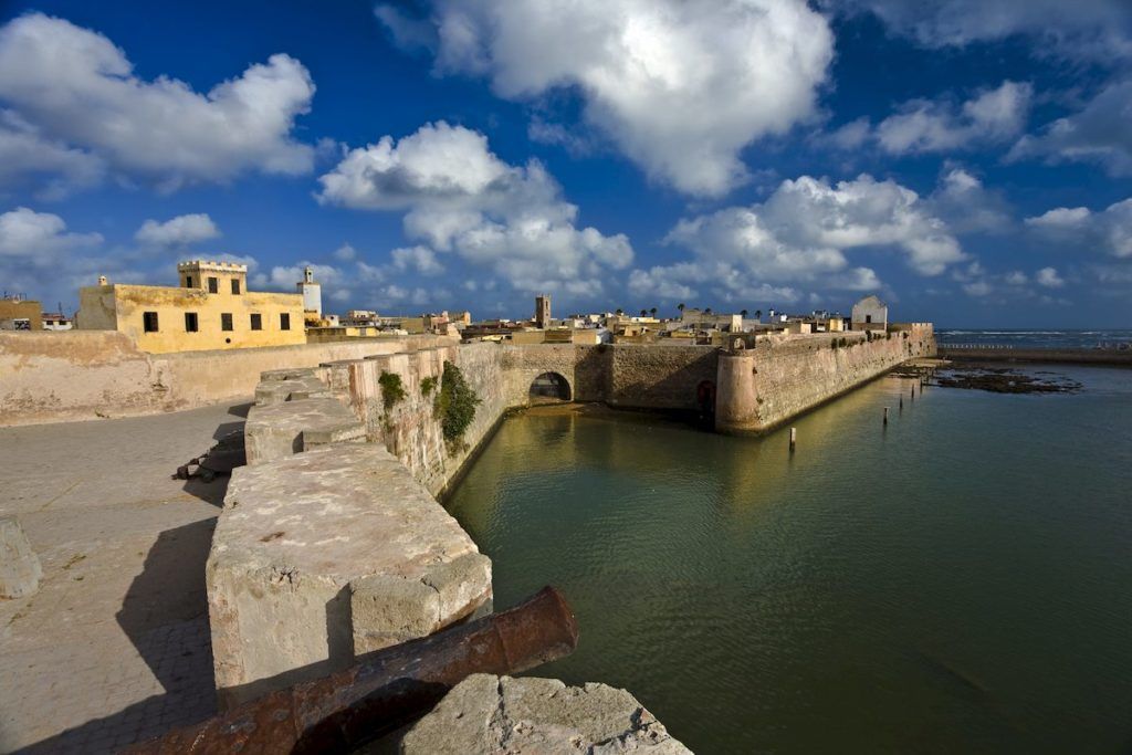 Brown and grey buildings overlooking the sea