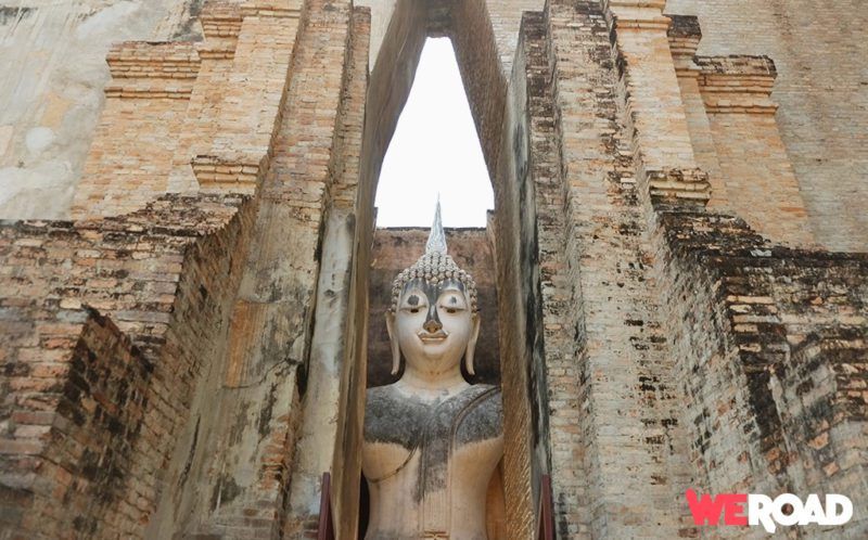 Buddah statue surrunded by ancient ruins during daytime