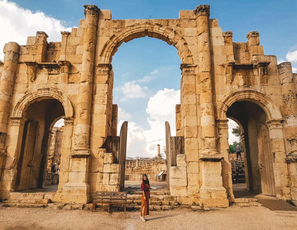 A womand stands in front of the Roman ruins at Jerash