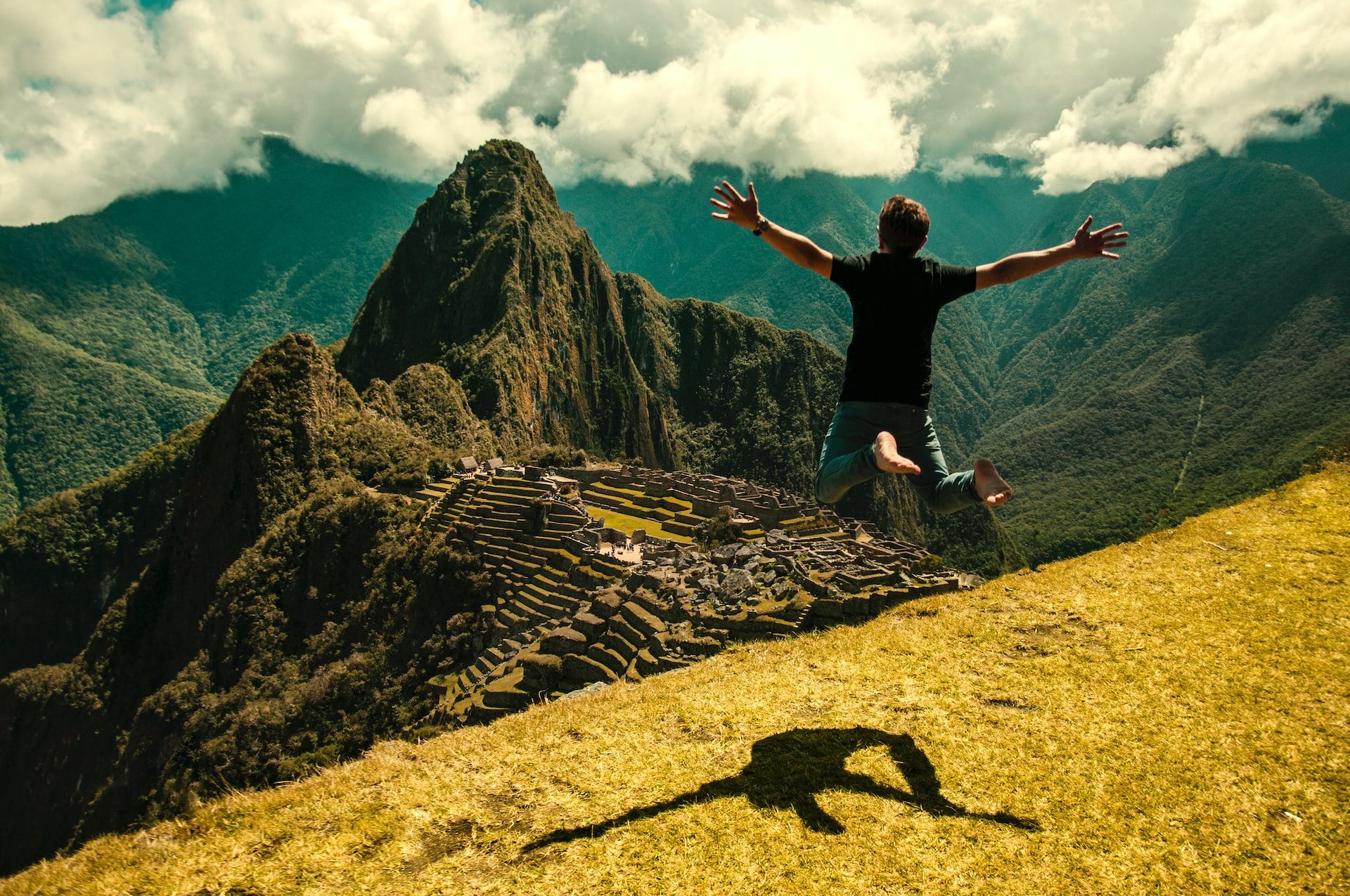 man jumping in green open field in Machu Picchu