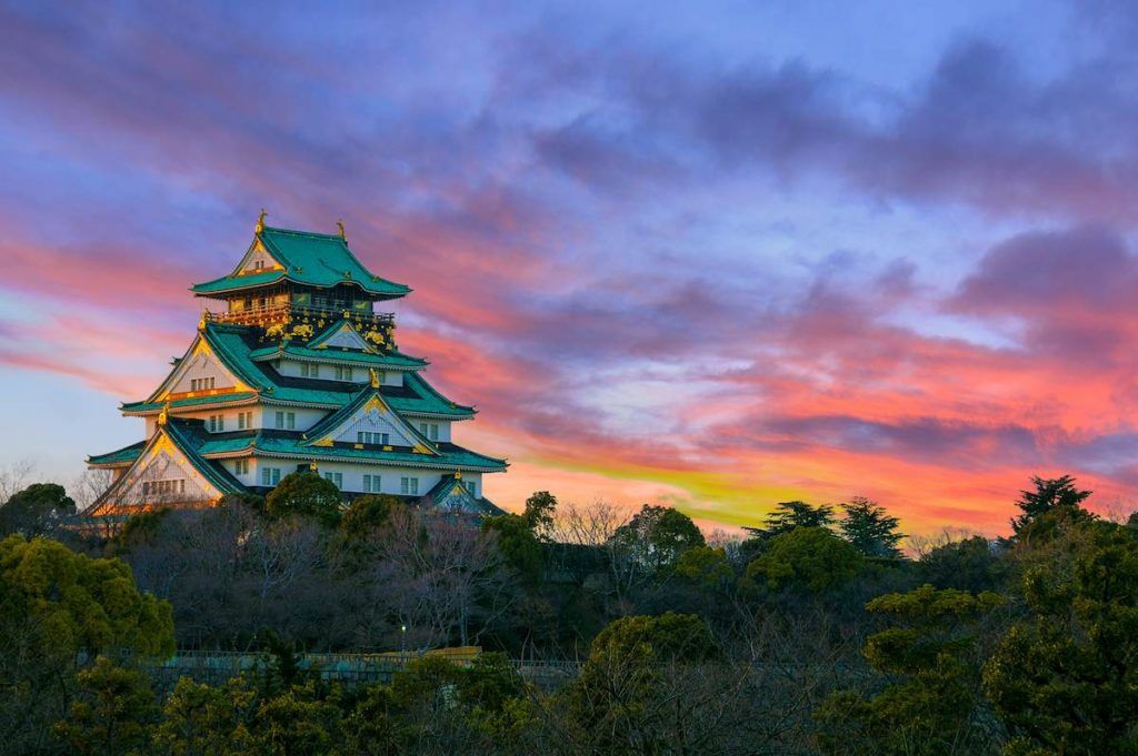 Osaka castle with trees at sunset