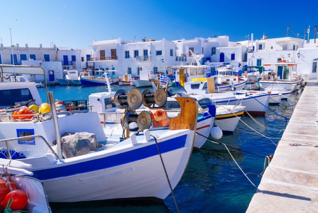 blue and white boats with white houses in the background
