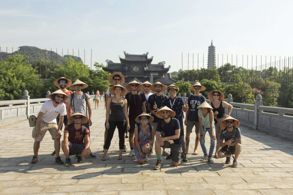 a group of people wearing typical hats pose for a photo in hue