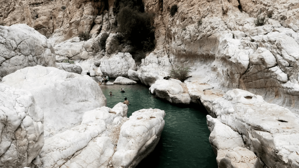 People bathing among the white rocks of Wadi Bani Khalid