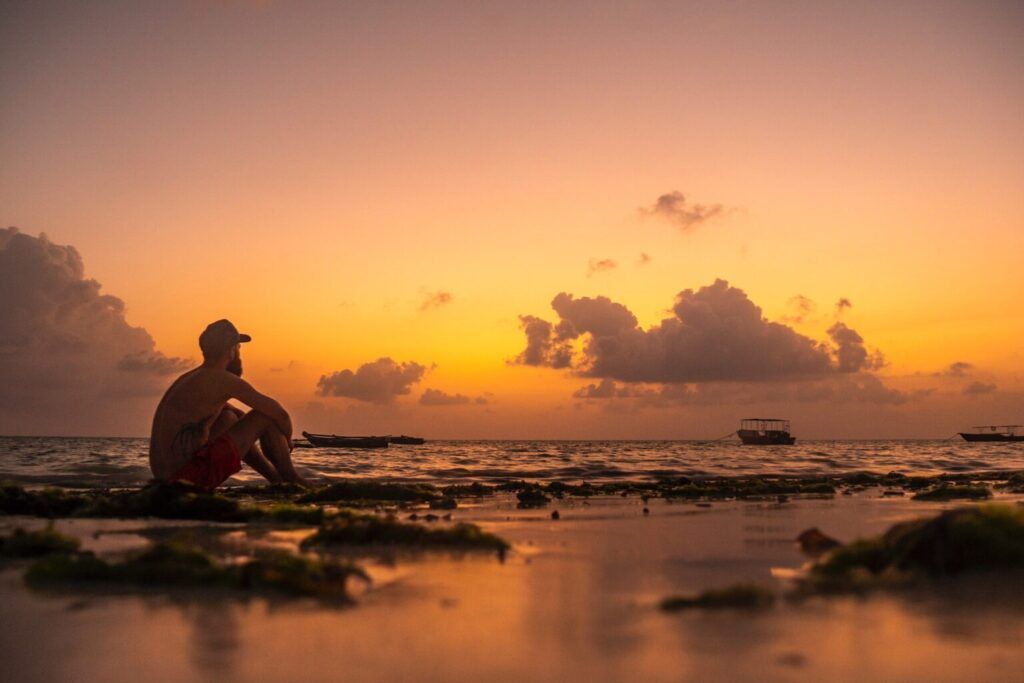 A guy looks at sunset on Paje beach in Zanzibar
