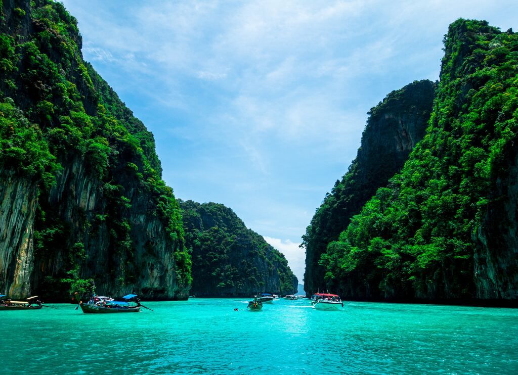 Boats on the sea near the mountain during the day in Phuket.