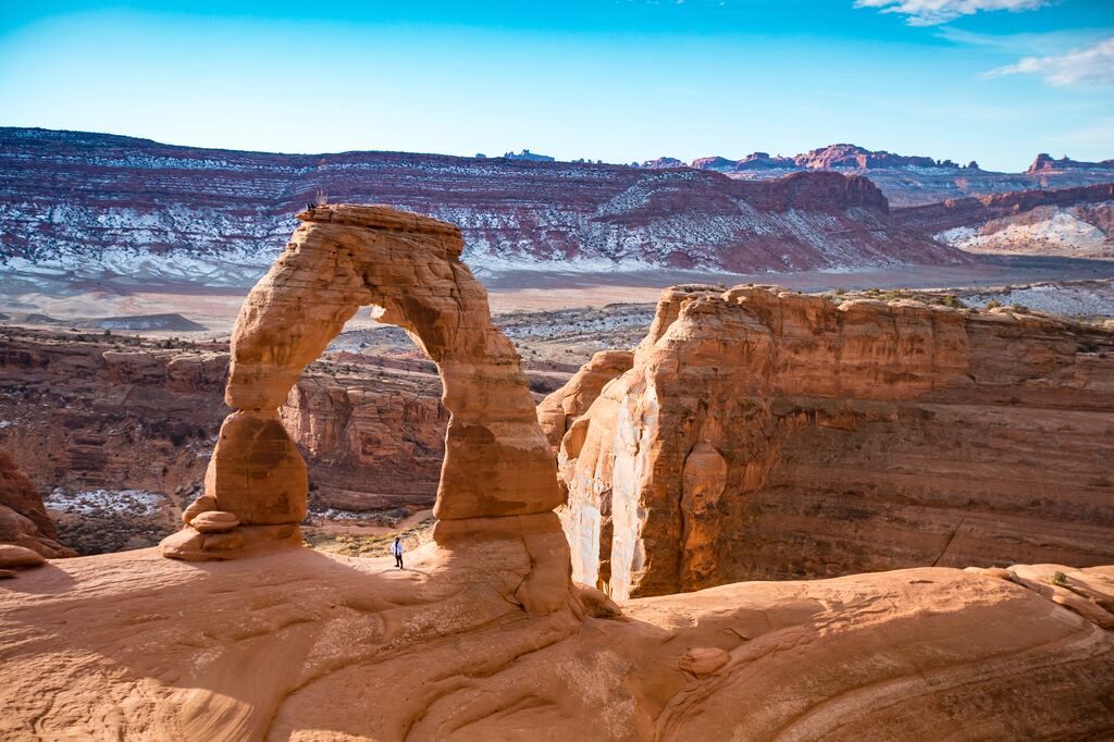 Brown rock formation under a blue daytime sky at Arches National Park.