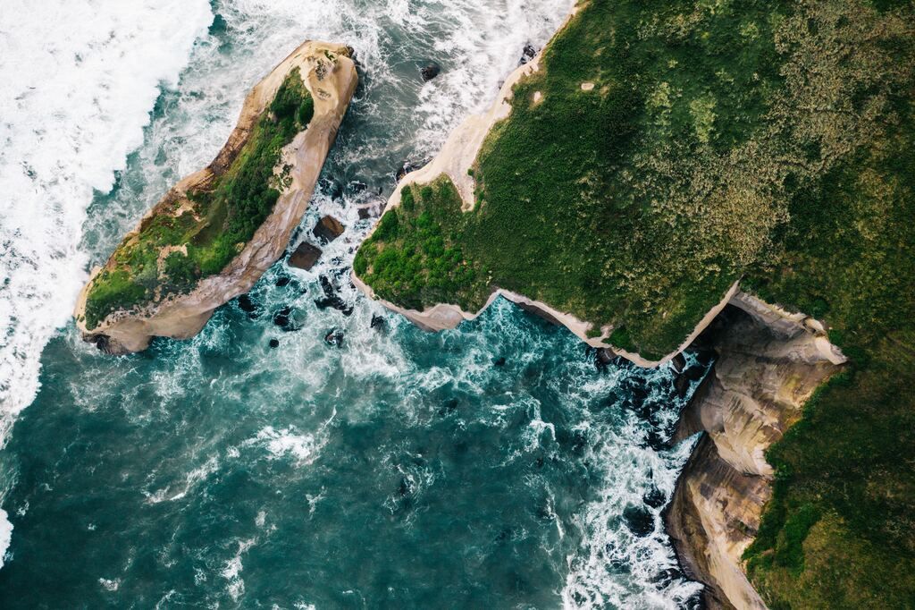 Brown rock formation next to the body of water during the day