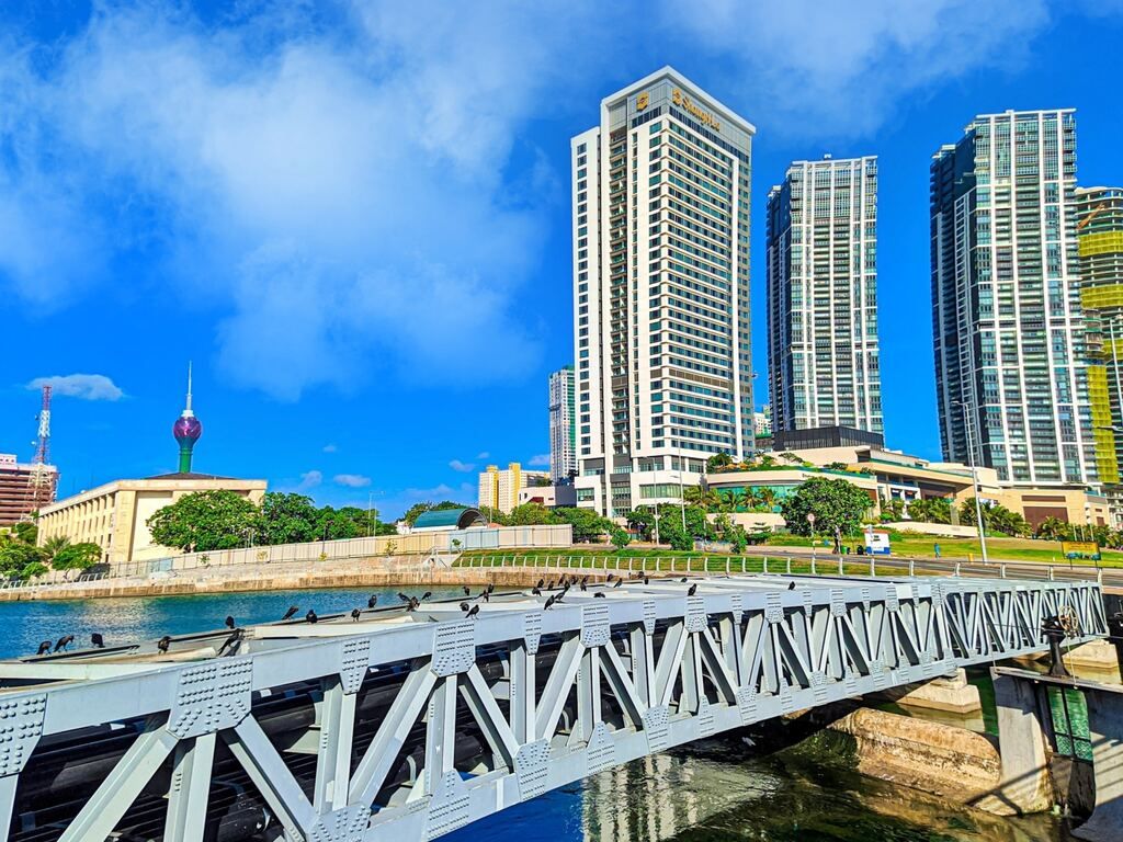 White bridge over the river near the city buildings during the daytime