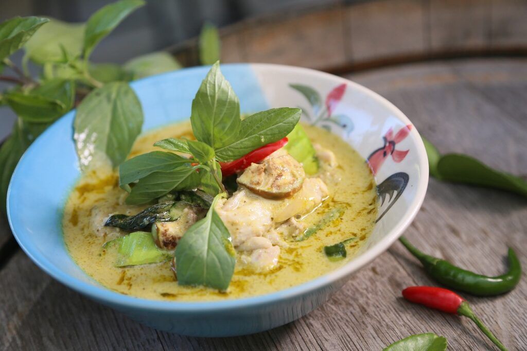green curry with chicken and vegetables in a blue plate