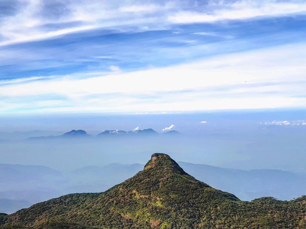 Green mountain under white clouds during the day