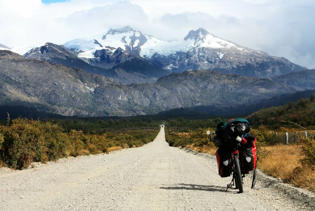 Black motorbike parked on the road towards the glacier mountain photo during the daytime