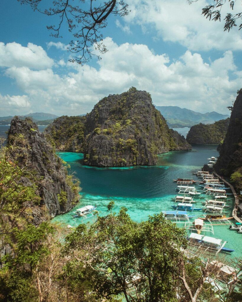 green and brown mountain beside body of water under blue sky during daytime.