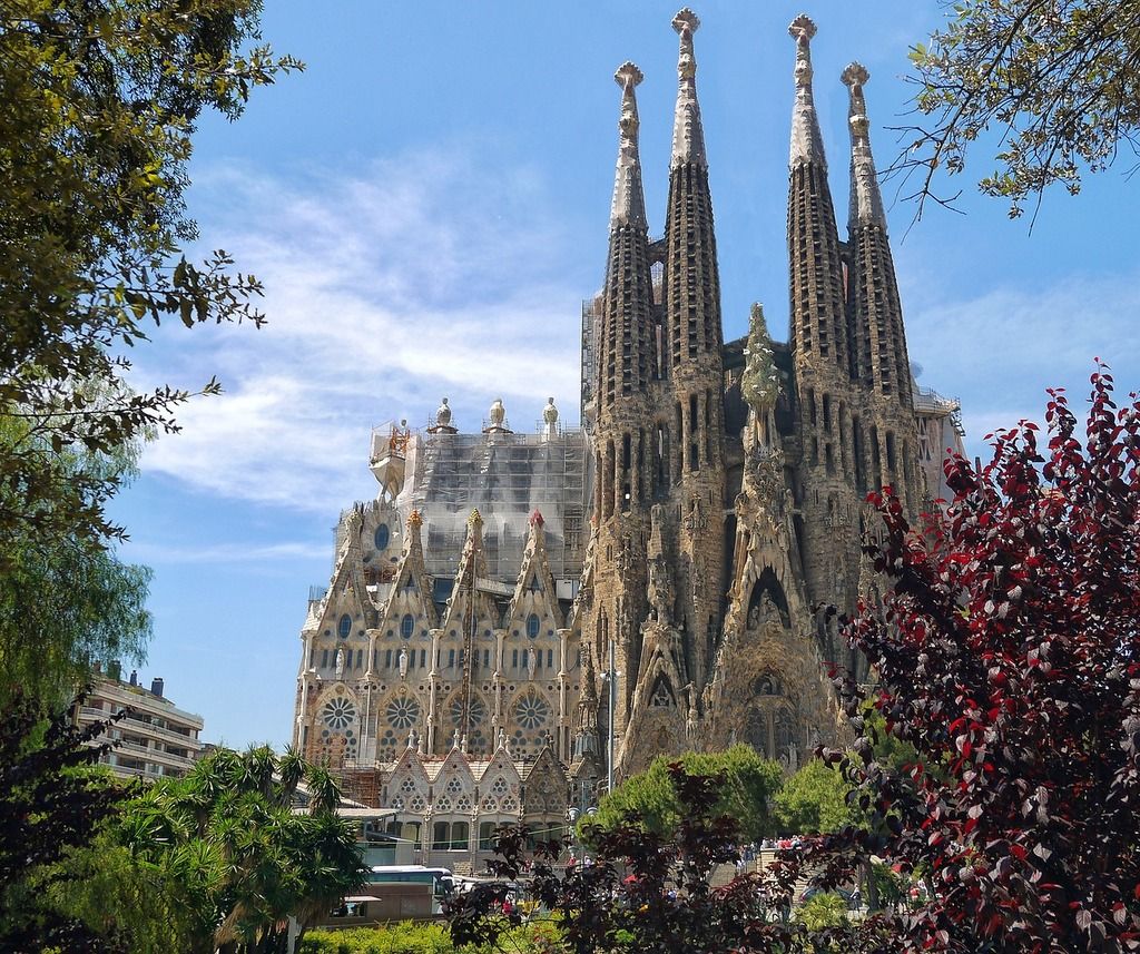 The iconic Sagrada Família basilica with its intricate towers reaching toward a blue sky in Barcelona.