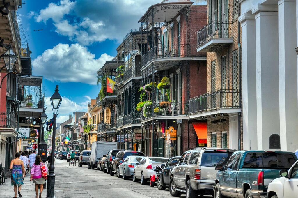 Colorful historic buildings with wrought-iron balconies in the lively French Quarter of New Orleans, Louisiana.