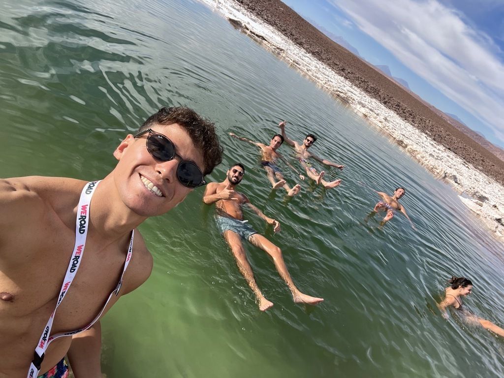 A group of WeRoad travelers enjoying a floating experience in a high-altitude salt lagoon.