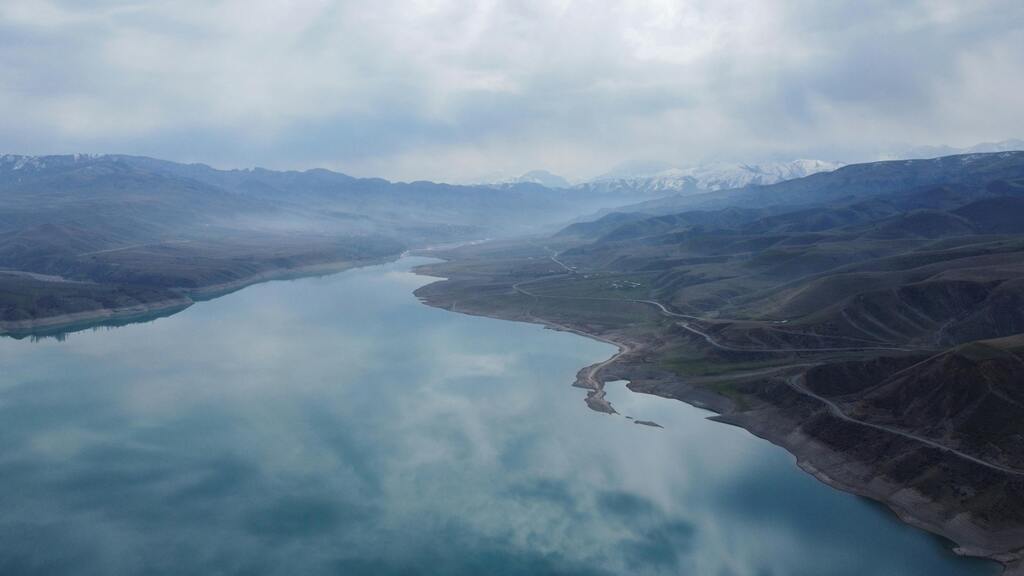 A wide shot of a lake in the mountainous landscape of Kyrgyzstan.