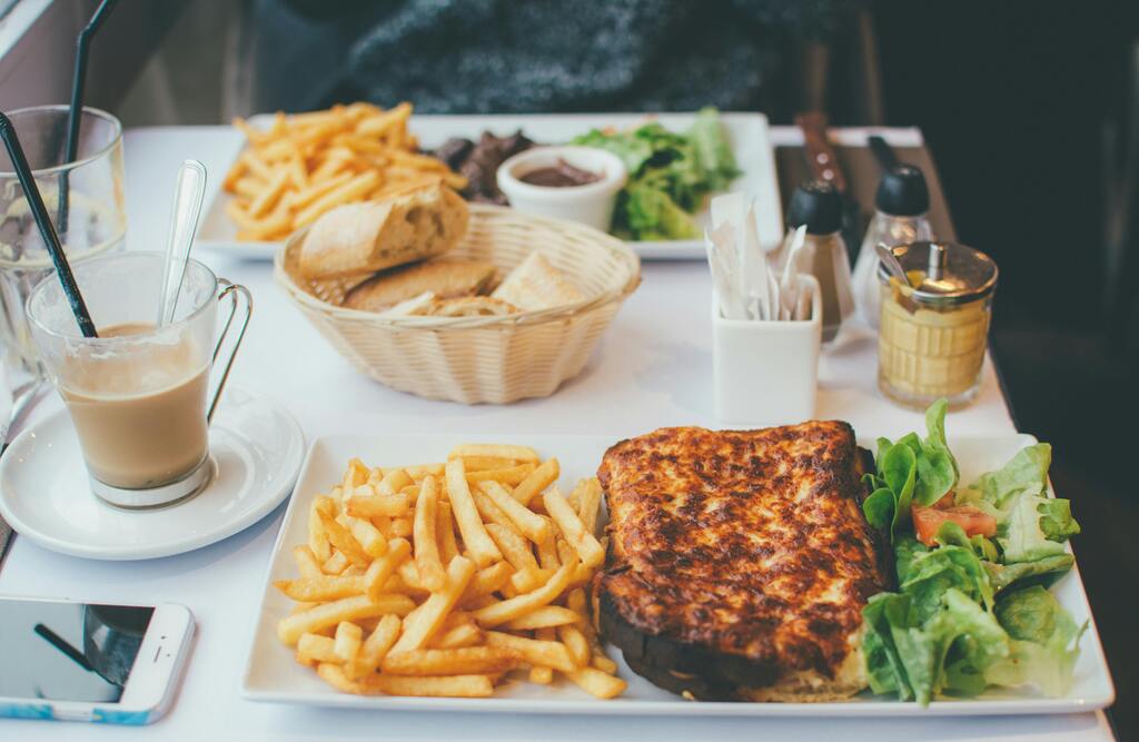 A classic French meal with a croque monsieur, French fries, and salad, served in a bistro.
