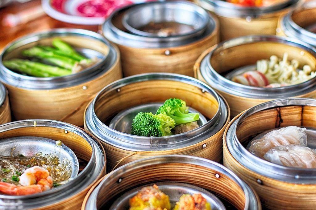 A variety of dim sum dishes in traditional bamboo steamers, a classic Cantonese culinary experience.