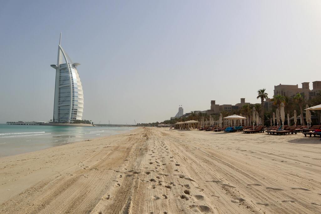 Burj Al Arab and luxury beach resort in Dubai with sun loungers
