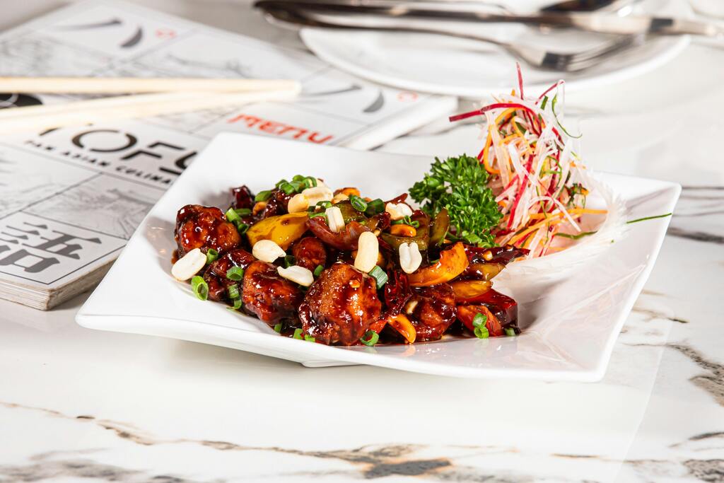 A plate of Kung Pao chicken, a popular Chinese dish with peanuts, vegetables, and spicy sauce.