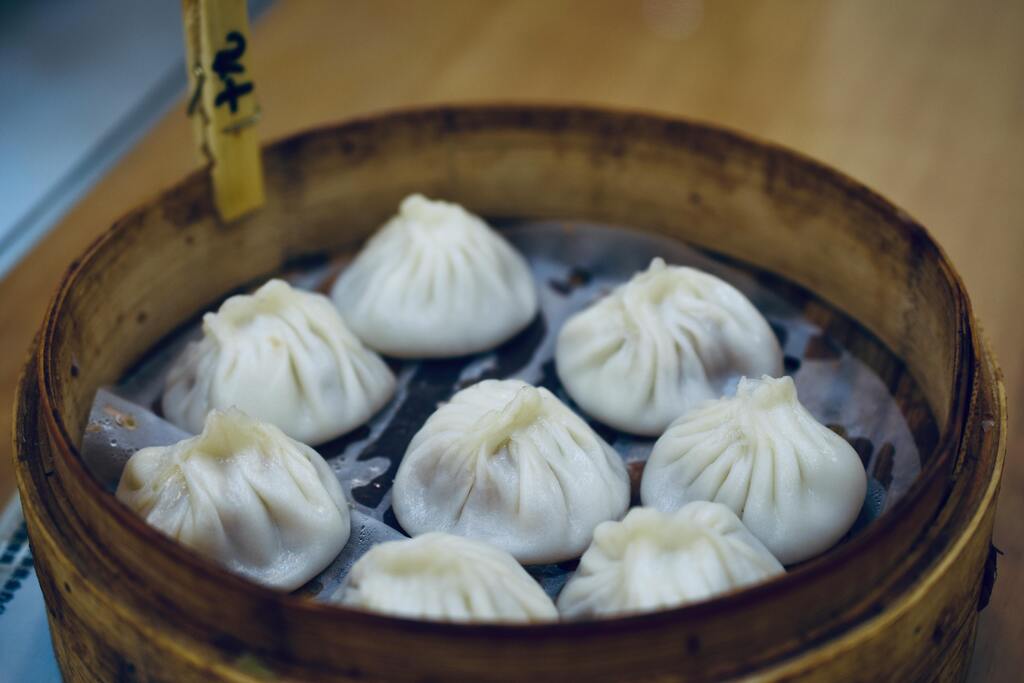 A bamboo steamer filled with freshly made xiao long bao, the famous Chinese soup dumplings.
