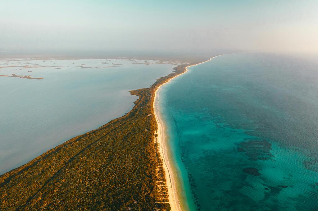 Endless white sandy beach stretching along the turquoise coastline, a dream destination for nature lovers.