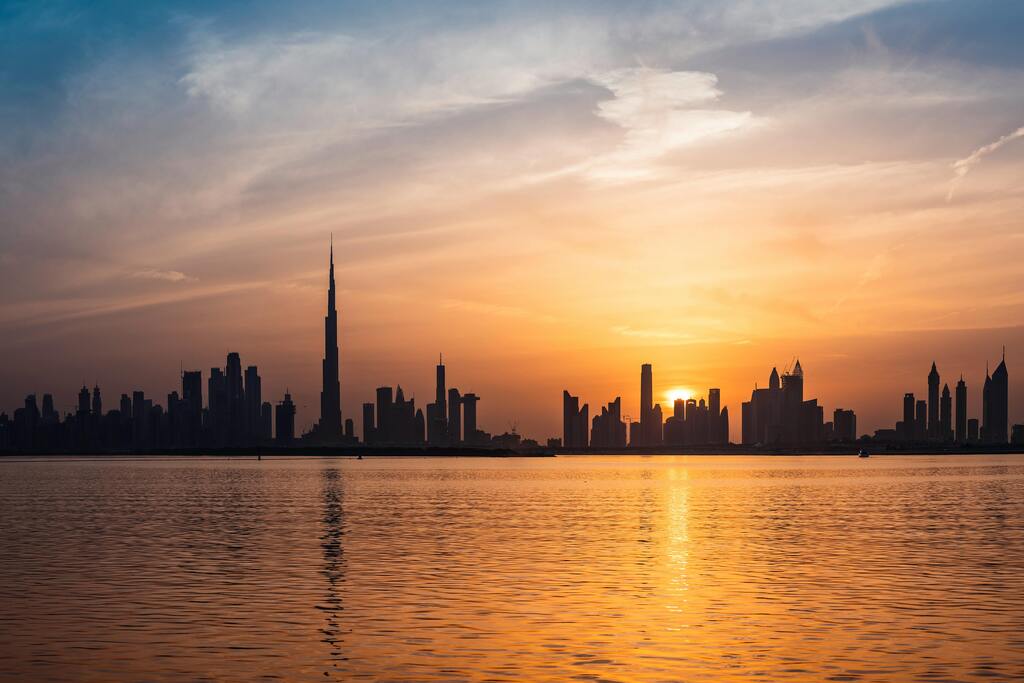 Dubai skyline at sunset with Burj Khalifa reflecting on the water
