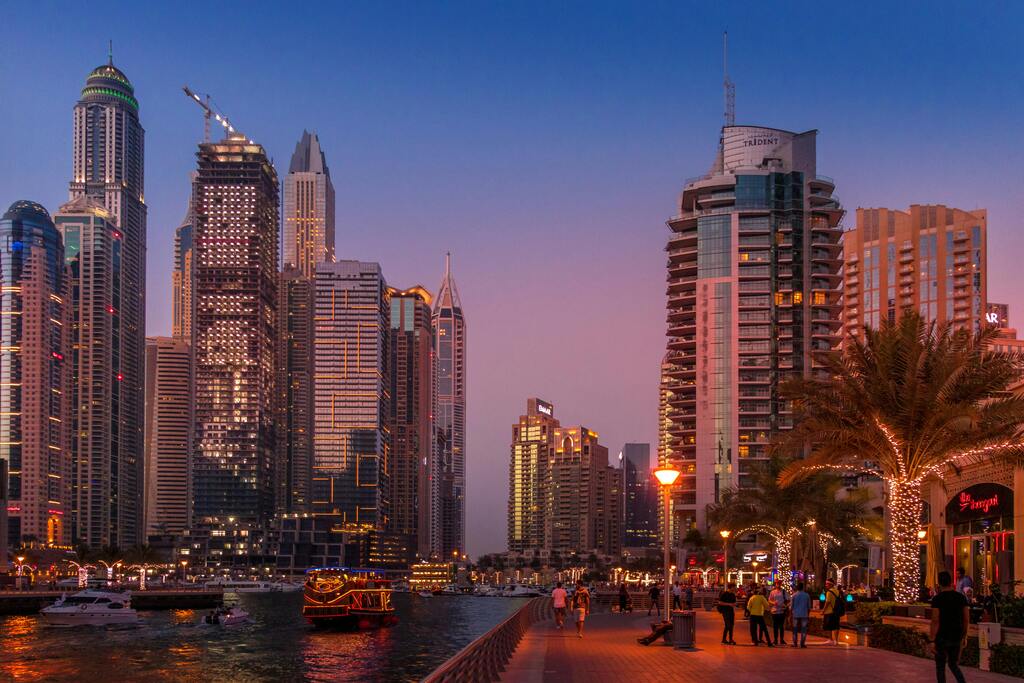 Dubai Marina at night with illuminated skyscrapers and waterfront promenade