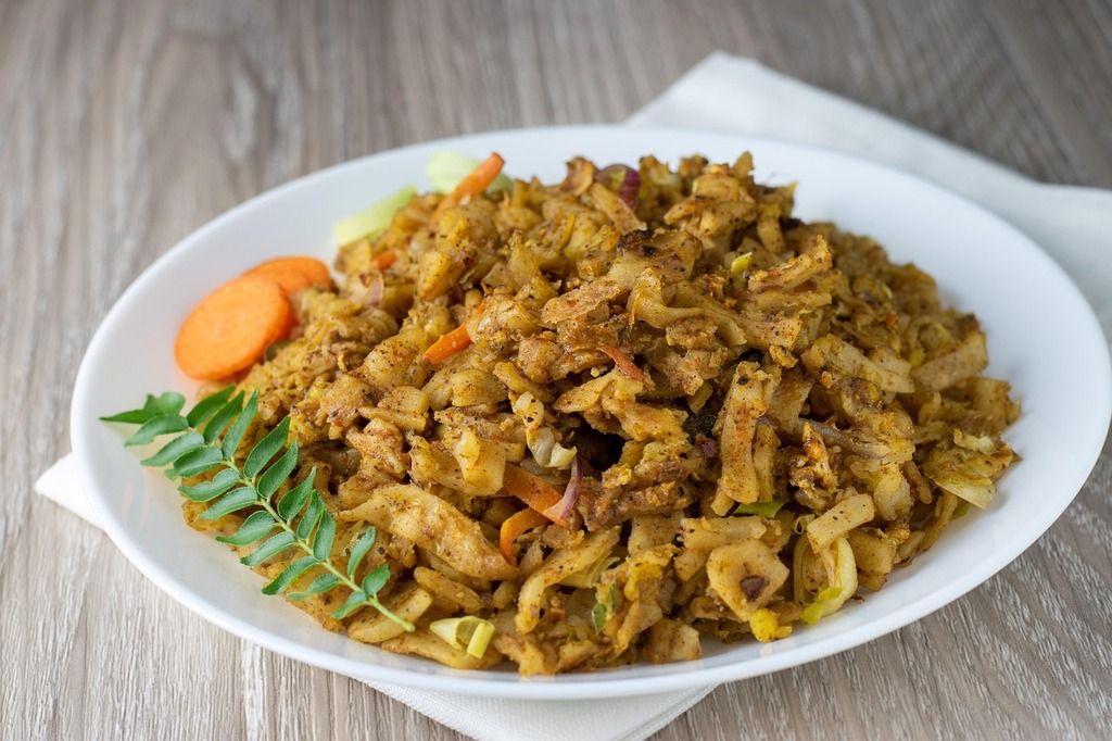 Sri Lankan Kottu Roti on a white plate, a chopped flatbread stir-fried with vegetables and spices