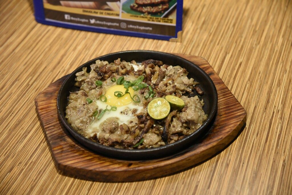 Sizzling sisig, a Filipino dish made with chopped pork and egg on a hot plate