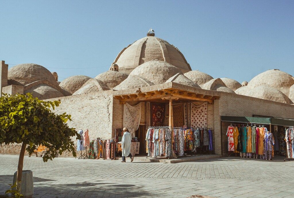 Traditional domed bazaar with colorful clothes on display in Uzbekistan