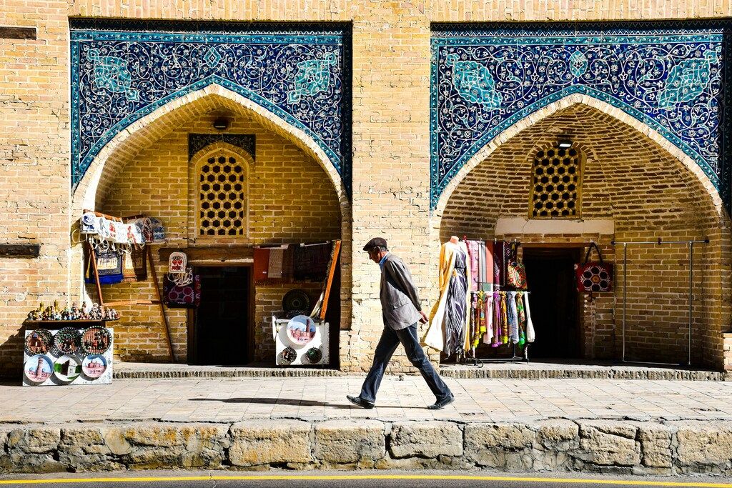 Man walking past traditional market stalls in Bukhara, Uzbekistan