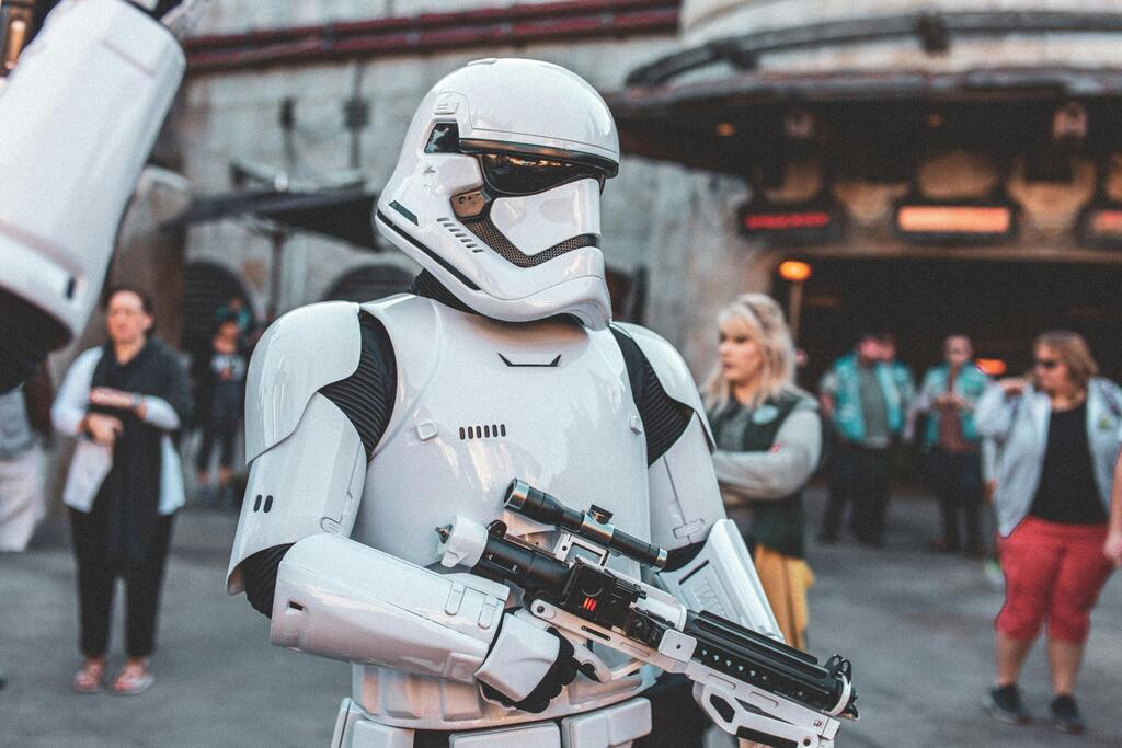 Stormtrooper in white armor holding a blaster at a themed event.