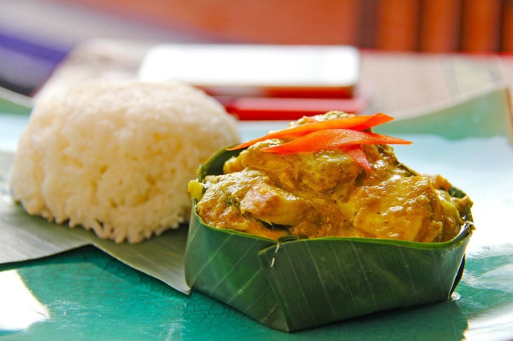 Traditional Cambodian fish amok served in a banana leaf bowl with steamed rice on the side.