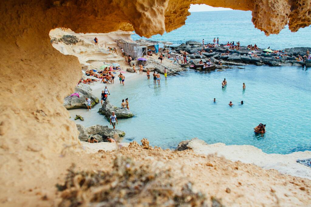 Natural rocky cove and crowded beach with turquoise waters in Formentera