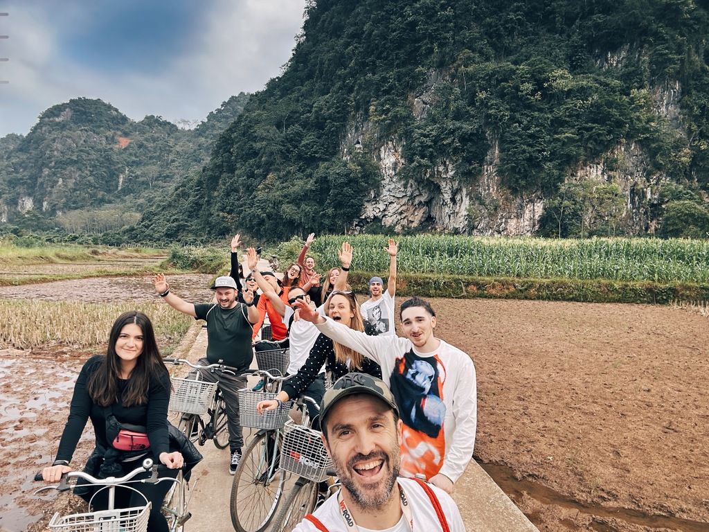 Group of travelers on bicycles smiling during a WeRoad adventure through the Vietnamese countryside