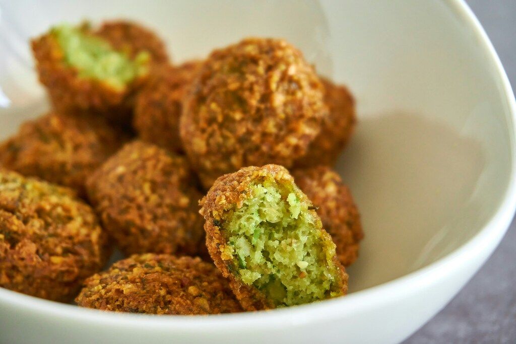 Crispy falafel with green herb filling in a white bowl