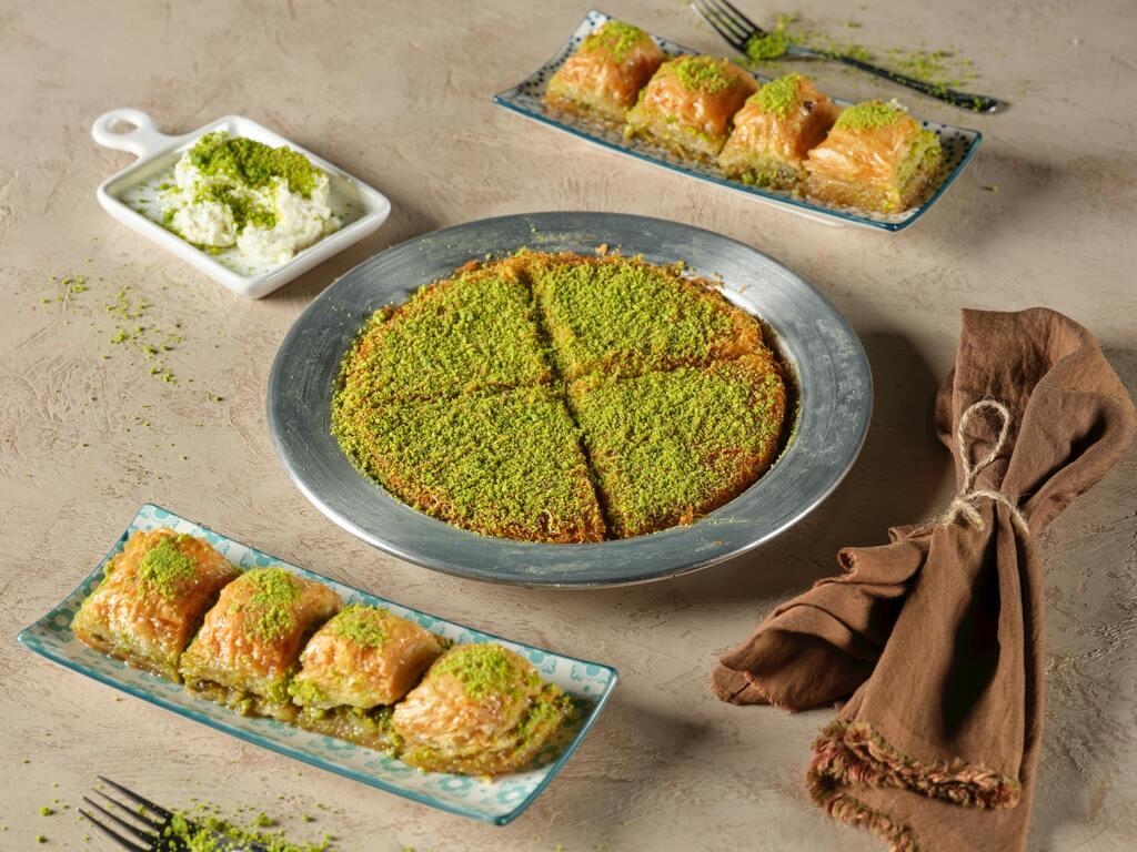 Plate of Middle Eastern desserts with baklava, kunafa and pistachio topping