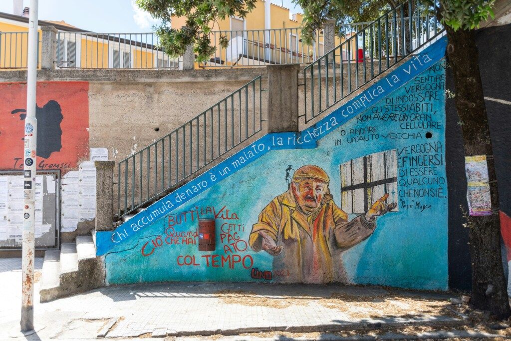 Street art mural with a quote by Pepe Mujica on a staircase wall in Orgosolo, Sardinia