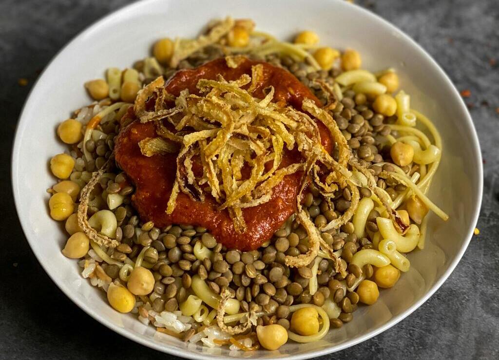 Traditional Egyptian koshari with lentils, chickpeas, pasta, tomato sauce and crispy onions