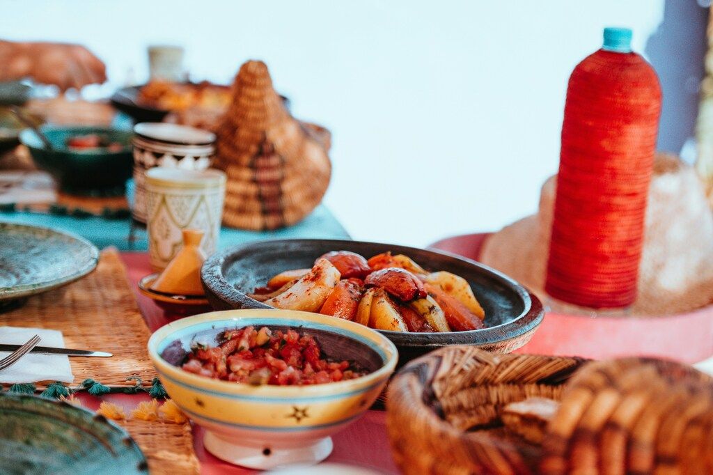 Traditional Moroccan meal with tagine and vegetables served on a vibrant table