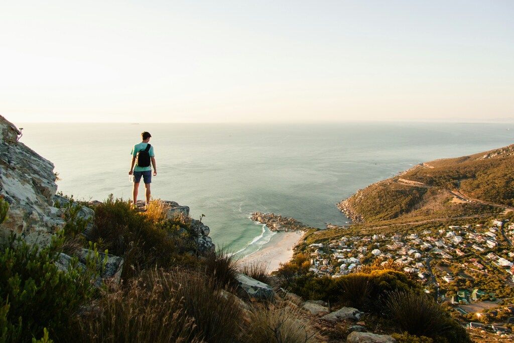 Hiker enjoying the view from a cliff above Camps Bay, Cape Town