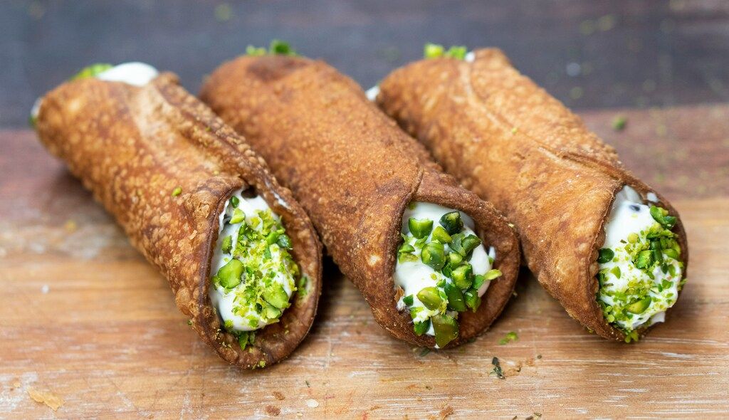 Classic Sicilian cannoli filled with ricotta cream and chopped pistachios