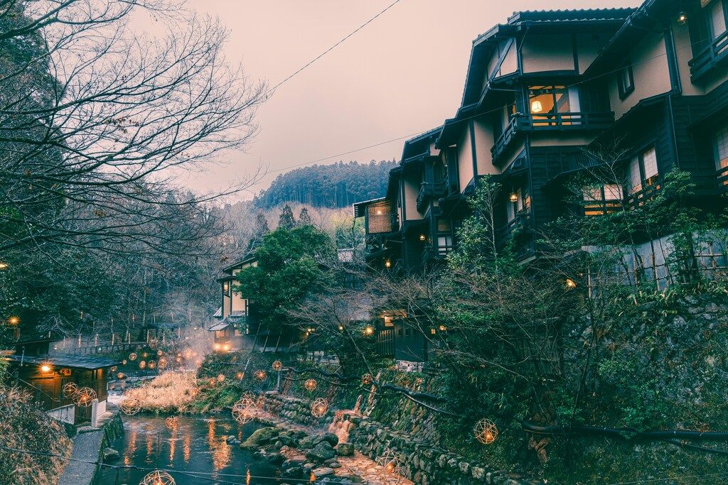 Magical evening view of a traditional Japanese village with river and lanterns