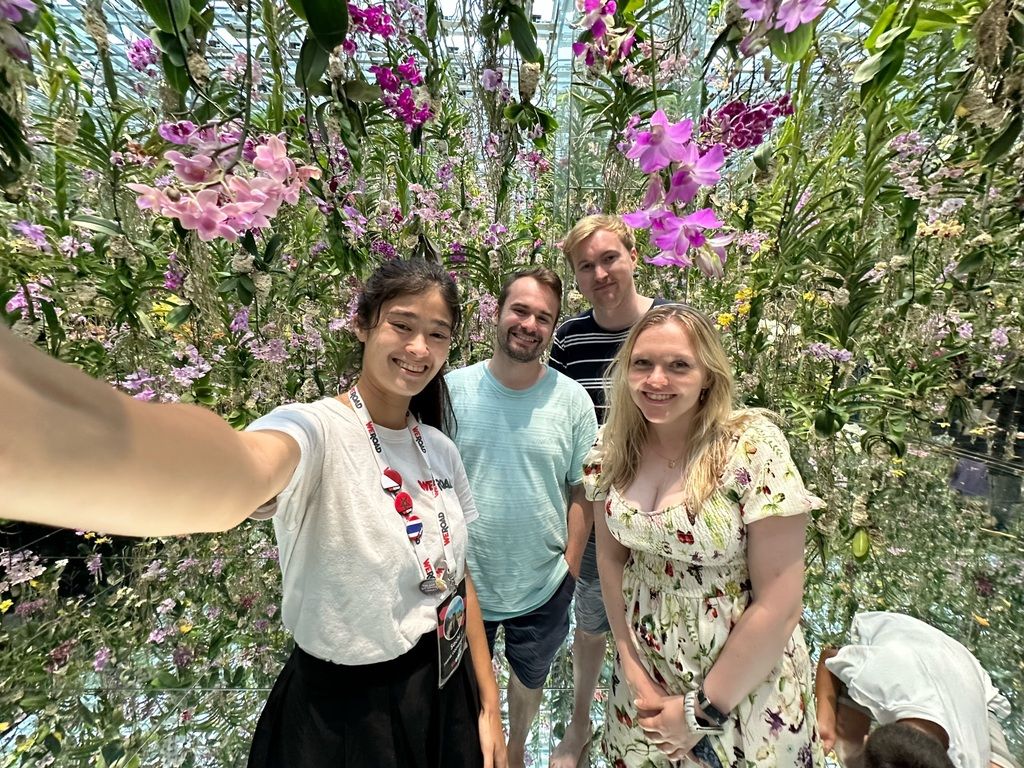 WeRoad group surrounded by hanging orchids in Japan.