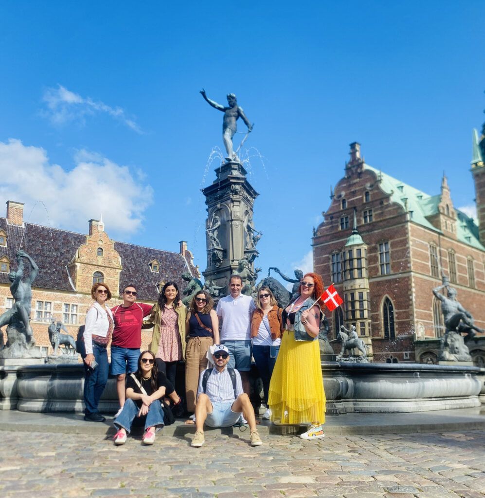 WeRoad group posing in front of the Neptune Fountain in the courtyard of Frederiksborg Castle, Denmark.