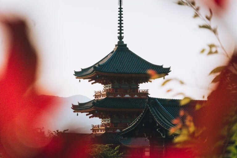 Autumn leaves frame a traditional Japanese temple in Kyoto.